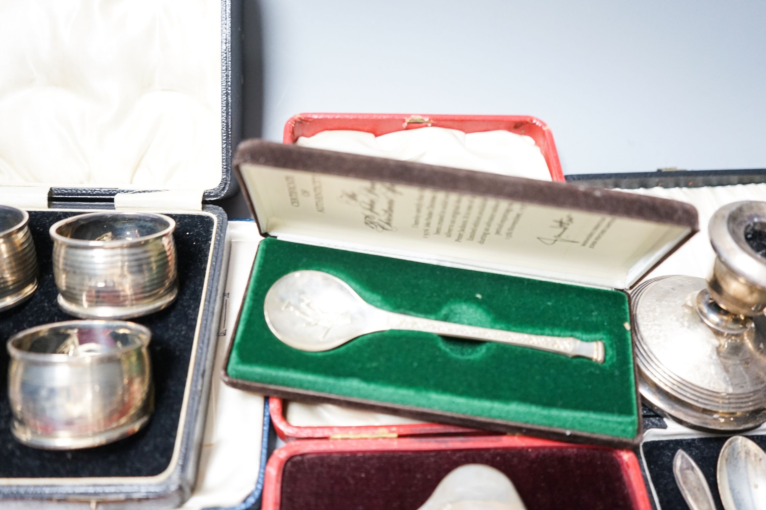 A cased pair of four 1920's silver napkin rings, four other cased items including butter shell and a pair of silver mounted dwarf candlesticks.